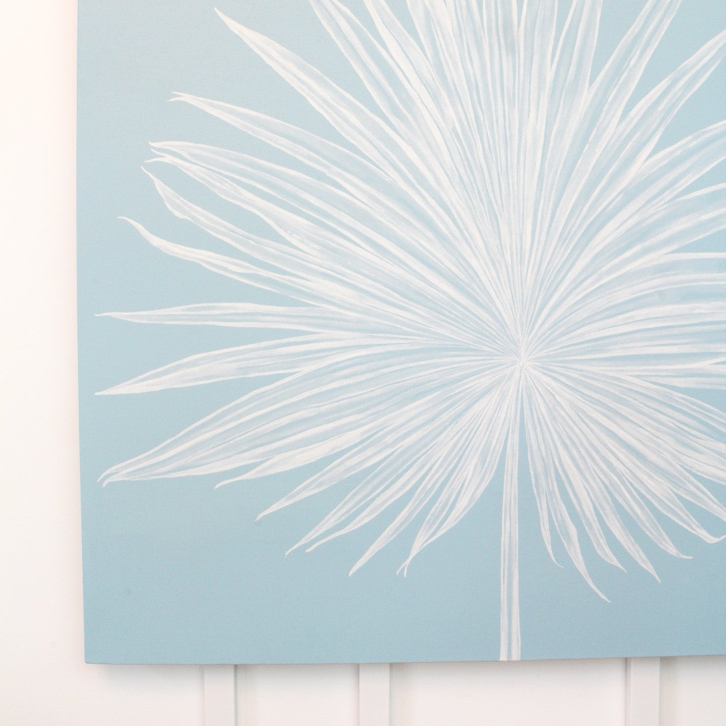 White palm leaf design on a light blue background