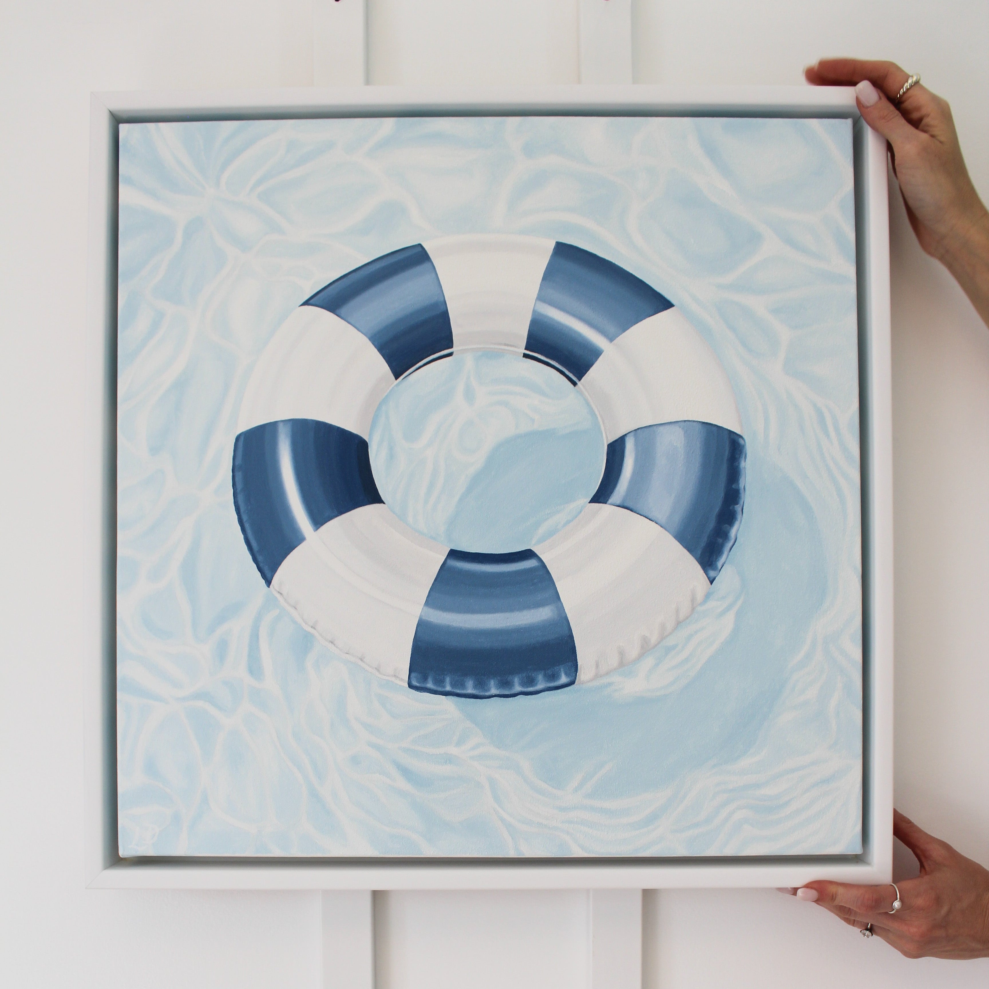 "License To Chill" original oil painting featuring a blue and white pool float on sparkling water in a white float frame.