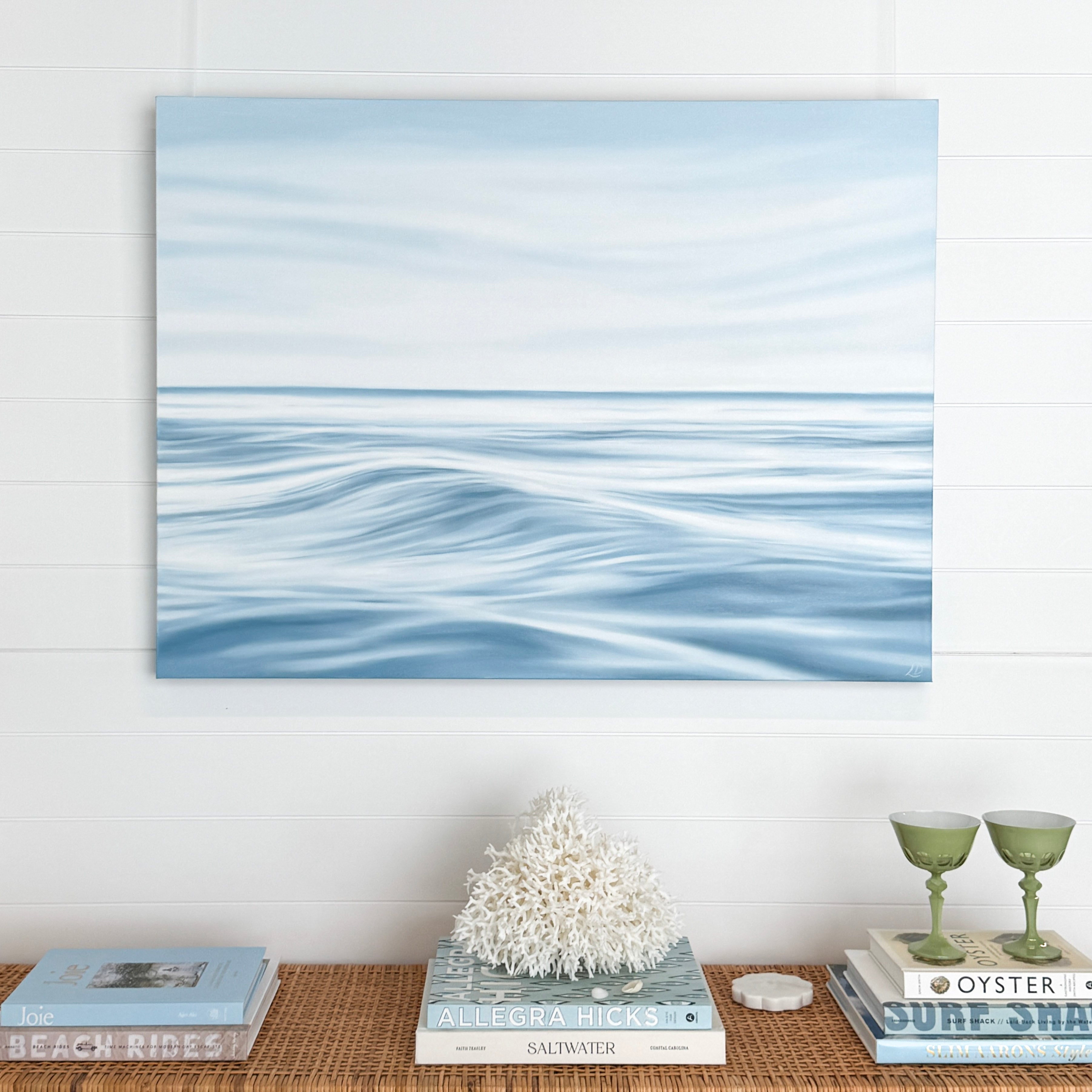 Calming Seas original coastal oil painting displayed above a sofa in a light coastal living room.